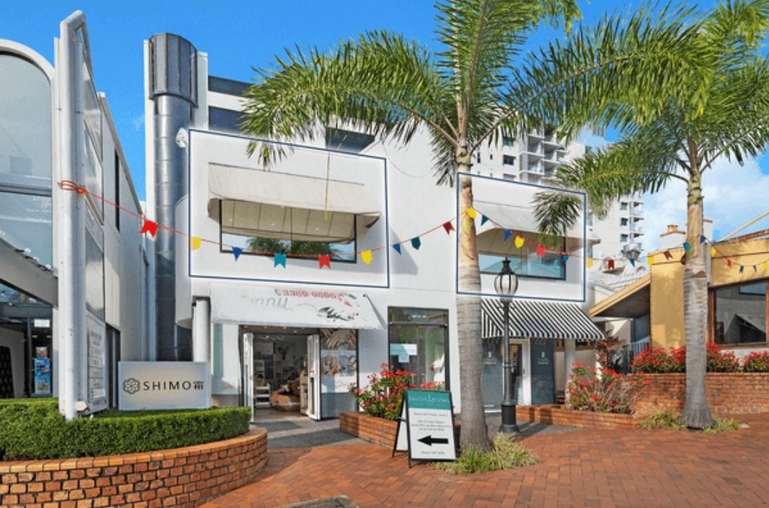 A building with palm trees in front of it.